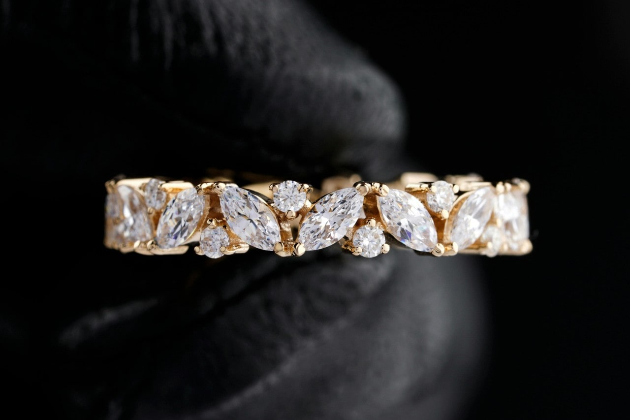 a yellow gold wedding band featuring both round and marquise cut diamonds