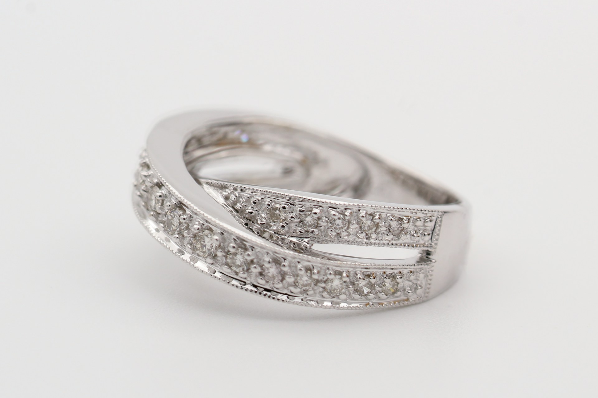 a white gold diamond fashion ring with an overlapping silhouette