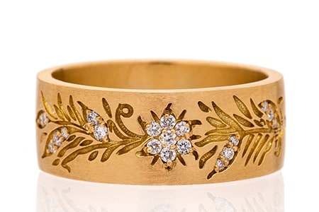 a gold ring with floral-inspired engravings and diamond details from Sethi Couture.