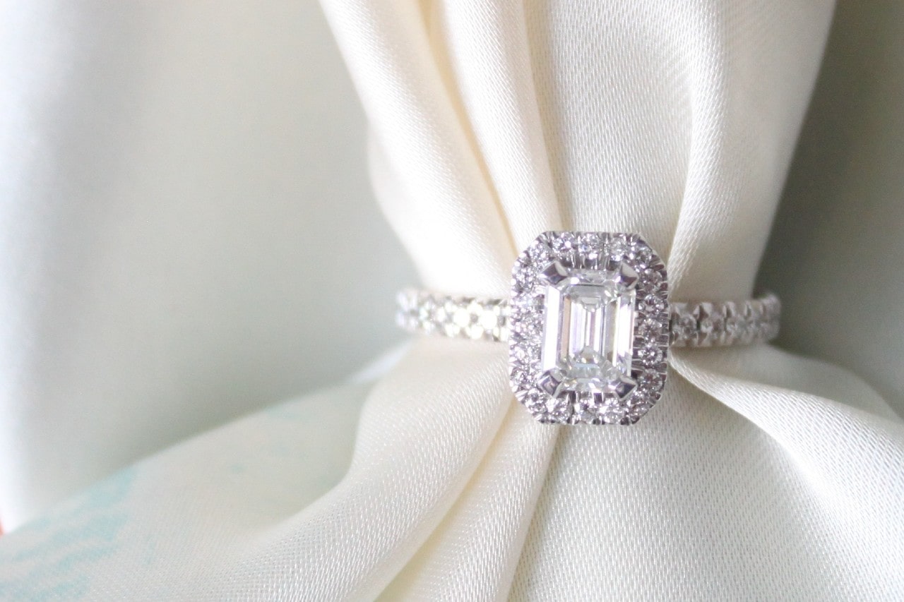 a white gold engagement ring on a piece of white fabric