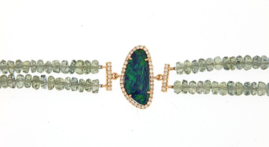 a beaded bracelet featuring two bands and a large blue and green opal at its center