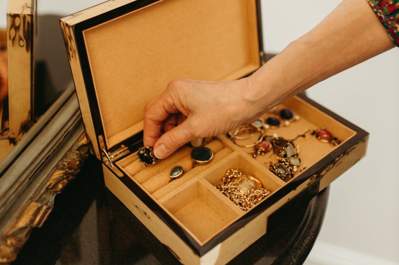 a person placing a ring into a soft travel jewelry case