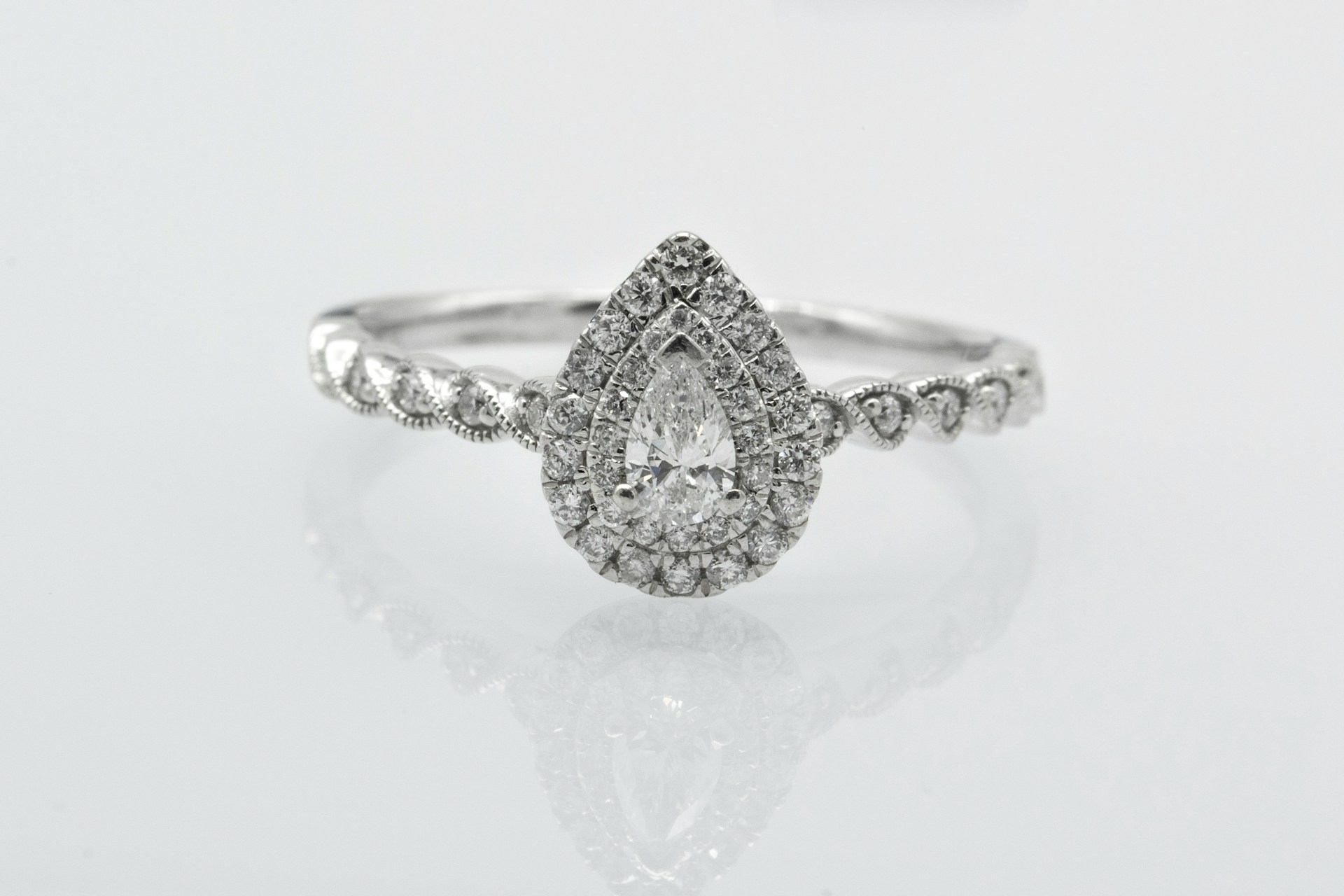 a white gold engagement ring featuring a pear shape diamond and diamond accents