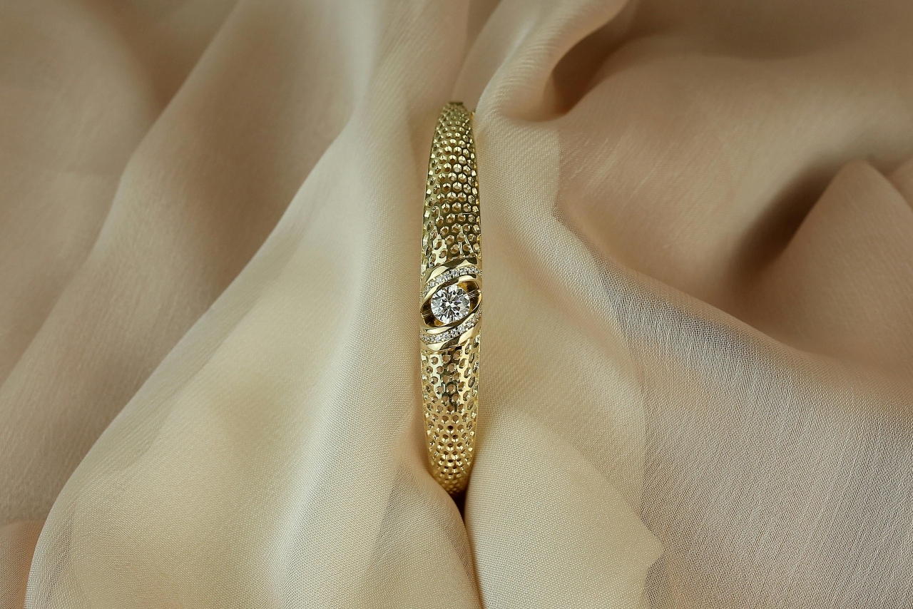 a yellow gold engagement ring with a unique wide band and small stone