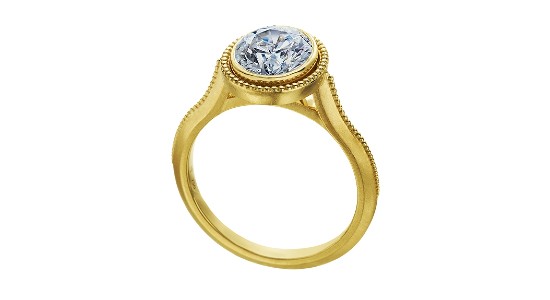 a yellow gold engagement ring with a bezel set center stone and milgrain detailing