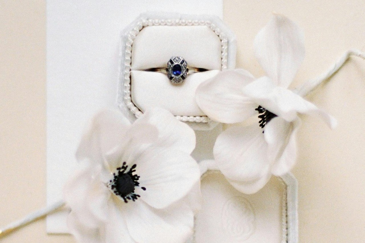 a white gold engagement ring with a sapphire center stone in a white ring box a white gold engagement ring with a sapphire center stone in a white ring box