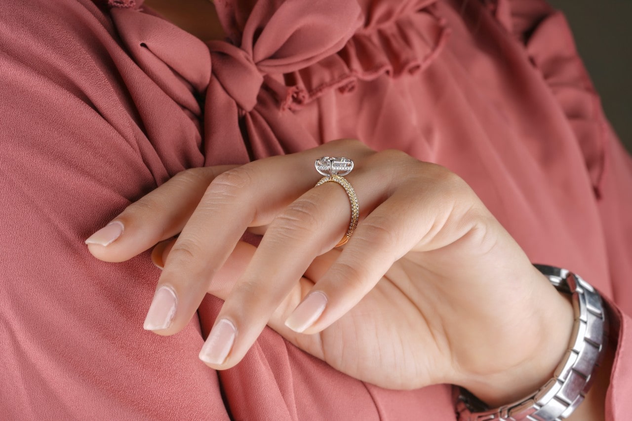 A hidden halo golden ring on a business woman's ring finger. A hidden halo golden ring on a business woman's ring finger.