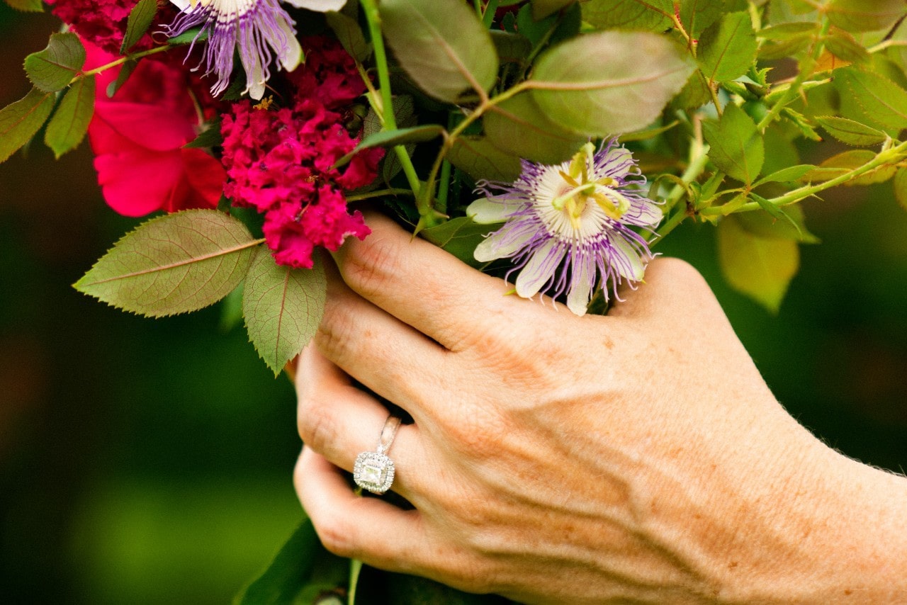 A woman holding a bouquet of flowers wears a halo ring. A woman holding a bouquet of flowers wears a halo ring.
