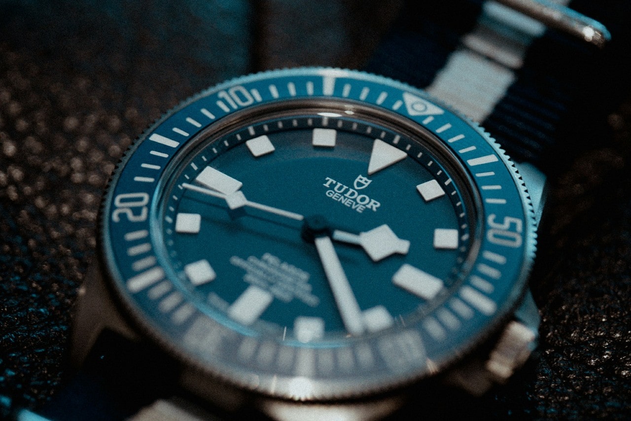 A close-up of a TUDOR watch with a blue dial and bezel. A close-up of a TUDOR watch with a blue dial and bezel.