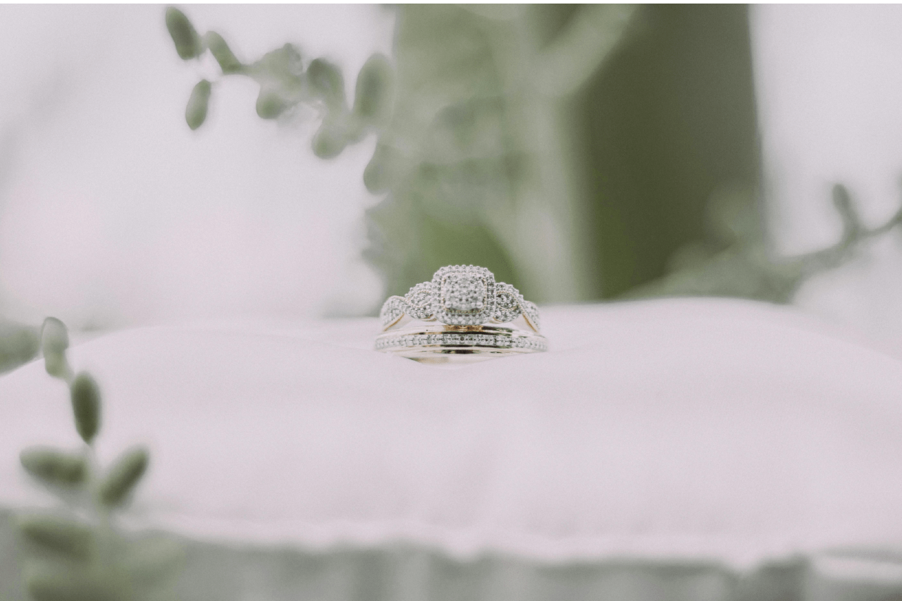 A distinctive engagement ring and wedding band displayed on a white pillow. A distinctive engagement ring and wedding band displayed on a white pillow.